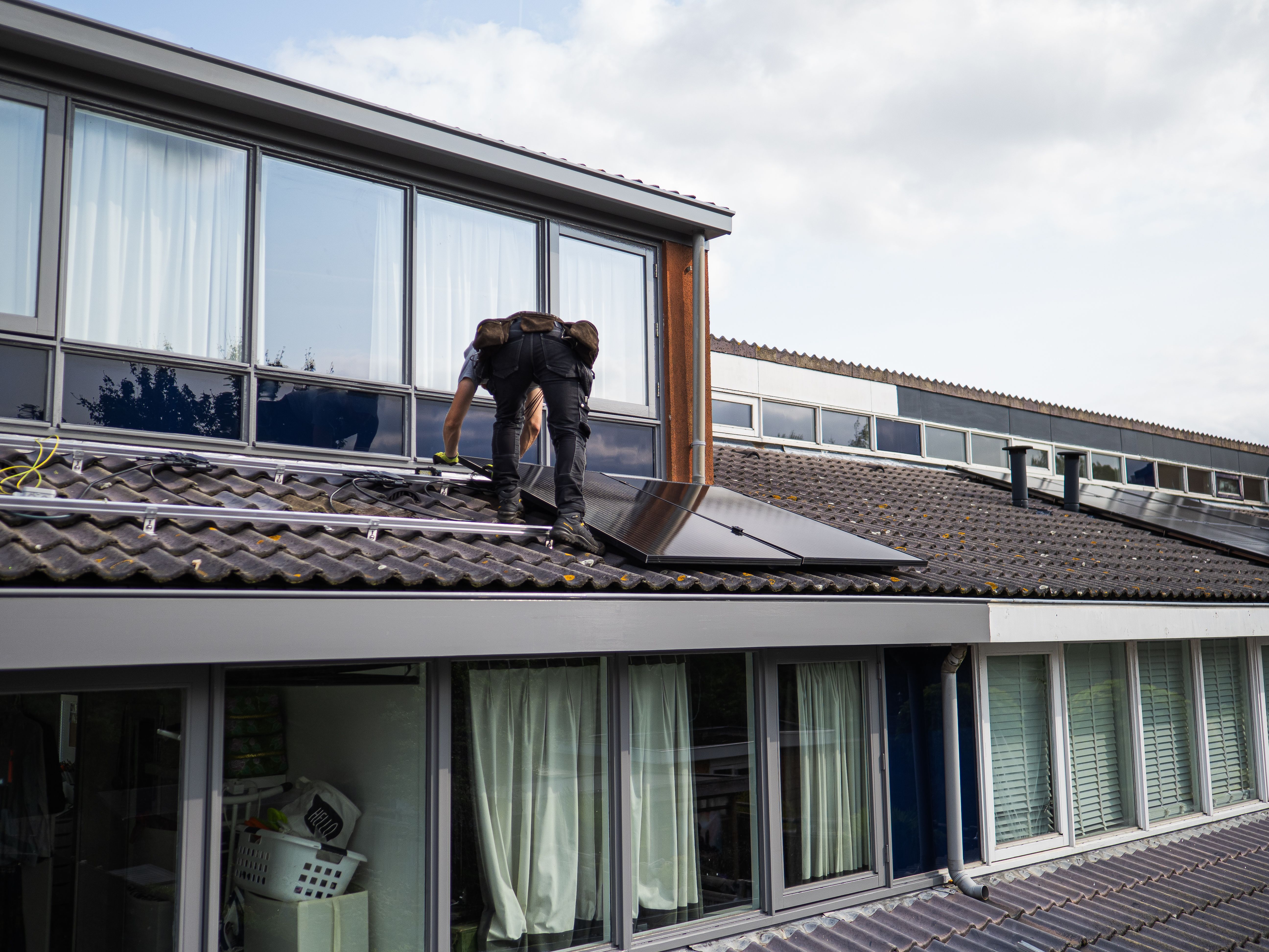 Technician installing solar panels on a residential rooftop